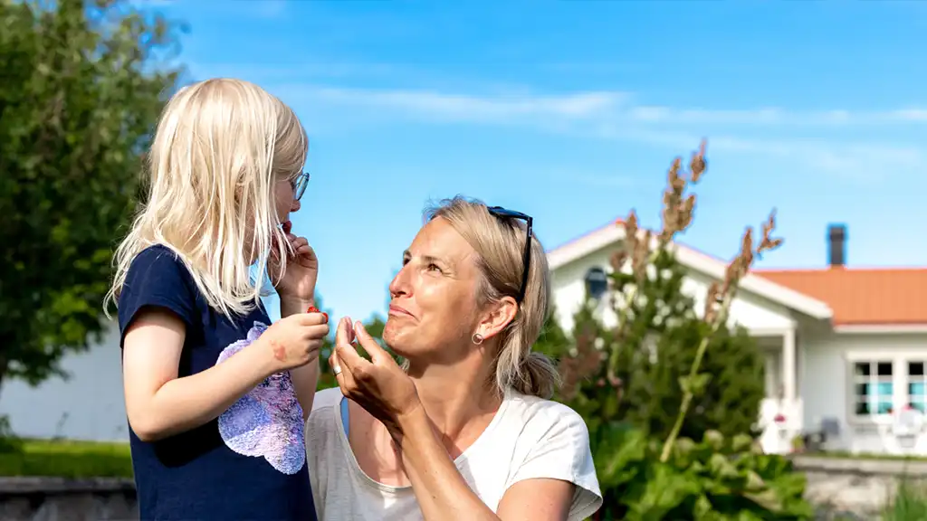 mor och dotter äter bär framför hus