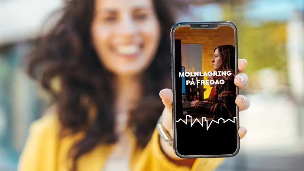 Kvinna håller upp mobiltelefon med film i